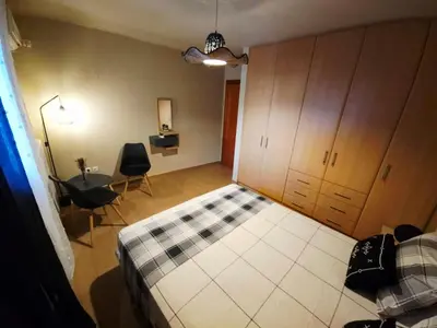 a bedroom with a bed and a desk and a table at Nefeli Villa lagonisi - Pool in Lagonissi