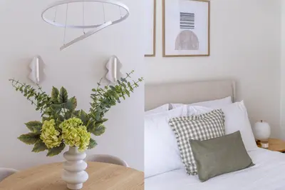a vase with flowers on a table next to a bed at Athens Heart Stay 1BR Apartment in Koukaki by UPSTREET in Athens