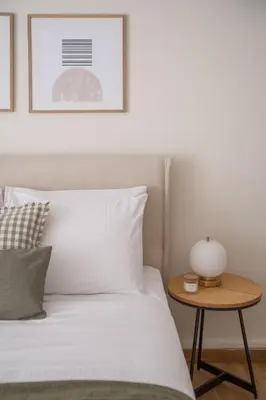 a bed with white sheets and a table with a lamp at Athens Heart Stay 1BR Apartment in Koukaki by UPSTREET in Athens