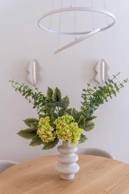 a white vase with yellow flowers on a table at Athens Heart Stay 1BR Apartment in Koukaki by UPSTREET in Athens