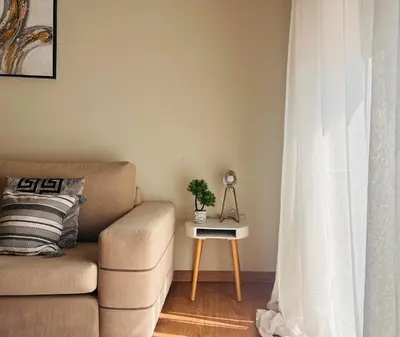 a living room with a couch and a table with a plant at Concert Hall Apartment - Semitelou in Athens