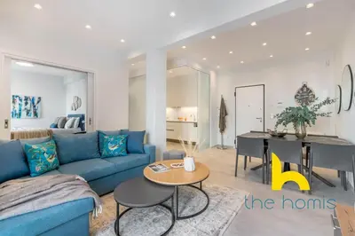 a living room with a blue couch and a table at Upscale central APT, Patio near Hospitals & Metro in Athens