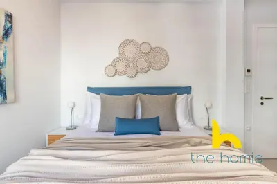 a bedroom with a large bed with a blue headboard at Upscale central APT, Patio near Hospitals & Metro in Athens