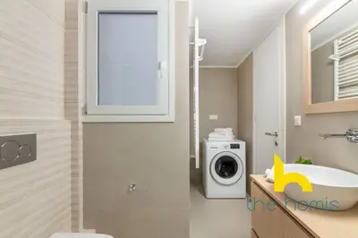 a bathroom with a washing machine and a sink at Upscale central APT, Patio near Hospitals & Metro in Athens