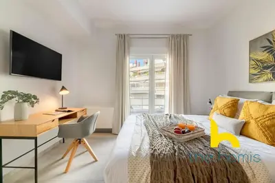 a bedroom with a desk and a bed with a tray of fruit on it at Upscale central APT, Patio near Hospitals & Metro in Athens