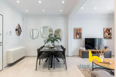 a dining room with a table and a tv at Upscale central APT, Patio near Hospitals & Metro in Athens