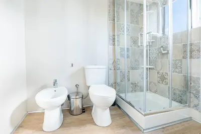 a bathroom with a toilet and a shower and a sink at Sun & Sea Escape Charming Vacation Apartment in Voula on Athen's Riviera in Athens