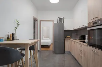 a kitchen with a table and a refrigerator at Orpheas Athens Comfy Apartment in Athens