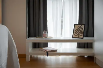a table with a candle on it next to a window at Orpheas Athens Comfy Apartment in Athens