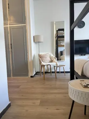 a bedroom with a bed and a chair and a table at Cosy studio in Pagrati Caravel, 4th floor in Athens