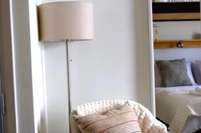 a lamp in a bedroom next to a bed at Cosy studio in Pagrati Caravel, 4th floor in Athens