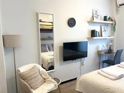 a living room with a mirror and a tv at Cosy studio in Pagrati Caravel, 4th floor in Athens