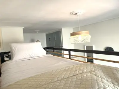 a bedroom with a bed and a pendant light at Cosy studio in Pagrati Caravel, 4th floor in Athens