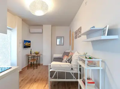 a living room with a couch and a table at Cozy Garden Studio in Athens
