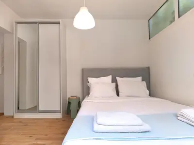 a bedroom with a bed with white sheets and pillows at Cozy Garden Studio in Athens