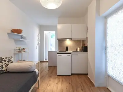 a small apartment with white cabinets and a kitchen at Cozy Garden Studio in Athens