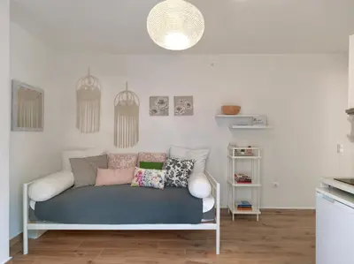 a couch with pillows on it in a living room at Cozy Garden Studio in Athens