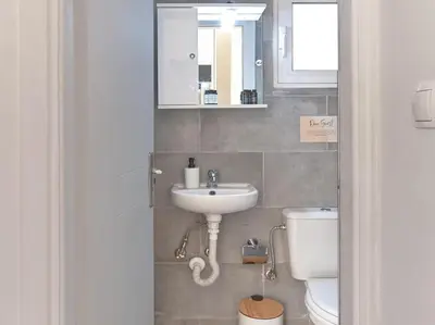 a bathroom with a sink and a toilet at Cozy Garden Studio in Athens