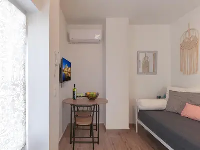 a small table in a small room with a bed at Cozy Garden Studio in Athens