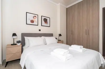 a bedroom with a large white bed with towels on it at Modern Apartment in Athens Center, 10 mins walk to Plaka Historical Area in Athens