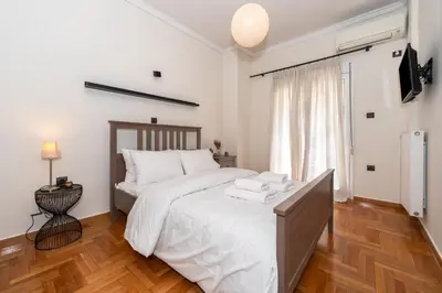 a bedroom with a large bed with white sheets at Modern Apartment in Athens Center, 10 mins walk to Plaka Historical Area in Athens