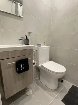 a white bathroom with a toilet and a sink at Zografou City Studio in Athens