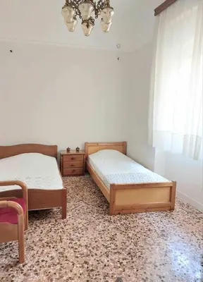 a bedroom with two beds and a chandelier at Κρεβάτια σε κοιτώνα 5' from metro in Athens