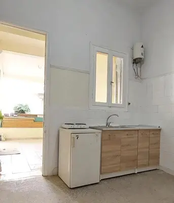 a white kitchen with a sink and a refrigerator at Κρεβάτια σε κοιτώνα 5' from metro in Athens