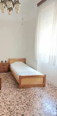 a bedroom with a wooden bed and a window at Κρεβάτια σε κοιτώνα 5' from metro in Athens