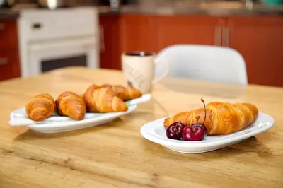 two plates of croissants and cherries on a table at Aroura Home 2BR Neos Kosmos in Athens