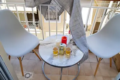 a glass table with two chairs and candles on it at Aroura Home 2BR Neos Kosmos in Athens