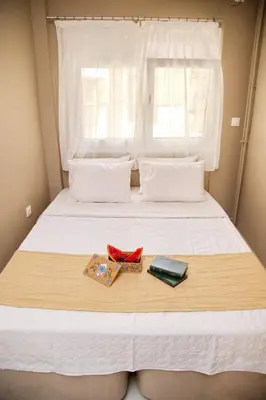 a bed with a window and two items on it at Aroura Home 2BR Neos Kosmos in Athens