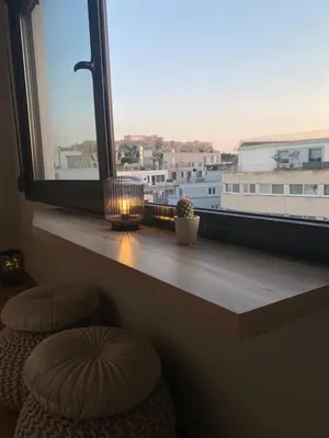 a window sill with two stools and a window with a view at Dionysos Suites in Athens