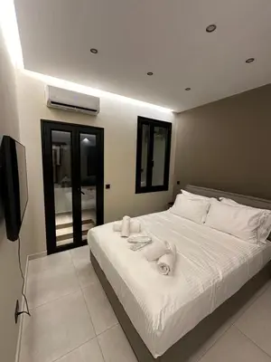 a bedroom with a white bed with towels on it at Dionysos Suites in Athens