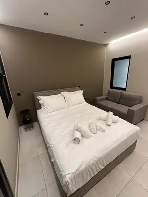 a bedroom with a bed with white sheets and a couch at Dionysos Suites in Athens