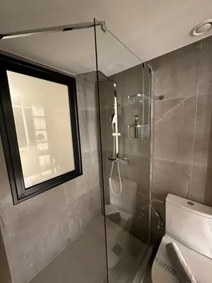 a bathroom with a shower and a toilet and a window at Dionysos Suites in Athens