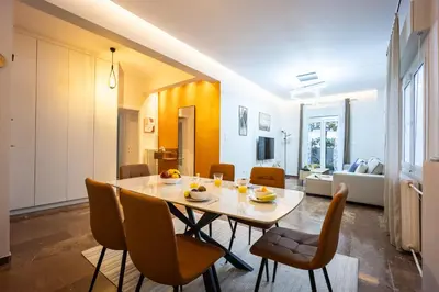 a dining room and living room with a table and chairs at Spacious Garden apt in Athens