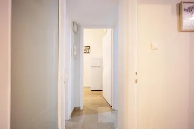 a hallway with white walls and a white refrigerator at Spacious Garden apt in Athens