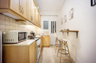 a kitchen with wooden cabinets and a microwave at Spacious Garden apt in Athens