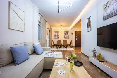 a living room with a couch and a tv at Spacious Garden apt in Athens