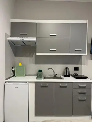 a kitchen with white cabinets and a sink at Aura Suite by Zeussuites in Athens