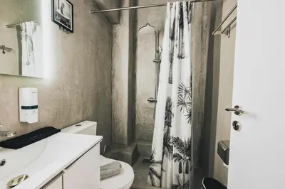 a bathroom with a shower curtain and a toilet at Aura Suite by Zeussuites in Athens