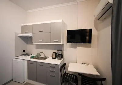 a small white kitchen with a sink and a table at Aura Suite by Zeussuites in Athens