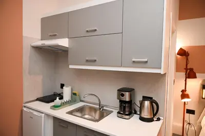 a kitchen with white cabinets and a sink at Iris Suite by Zeussuites in Athens