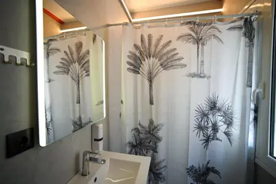 a bathroom with a shower curtain with palm trees at Plaka Central Suite by Zeussuites in Athens