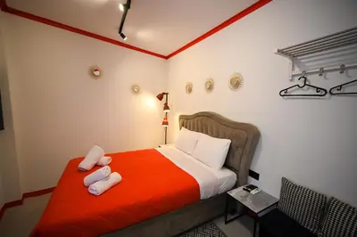 a bedroom with a bed with red sheets and white pillows at Plaka Central Suite by Zeussuites in Athens