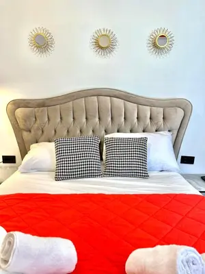 two mirrors above a bed with a red blanket at Plaka Central Suite by Zeussuites in Athens