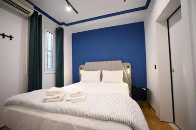 a bedroom with blue walls and a bed with towels on it at Monastiraki Suite by Zeussuites in Athens