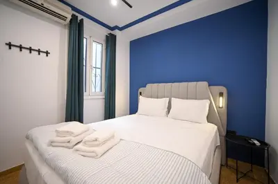 a bedroom with blue walls and a bed with towels on it at Monastiraki Suite by Zeussuites in Athens