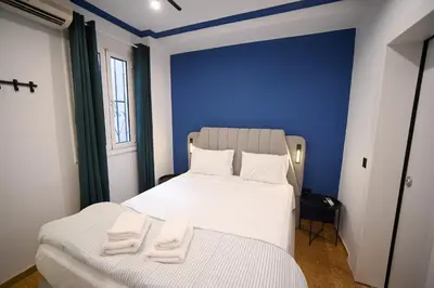 two beds in a room with a blue wall at Monastiraki Suite by Zeussuites in Athens